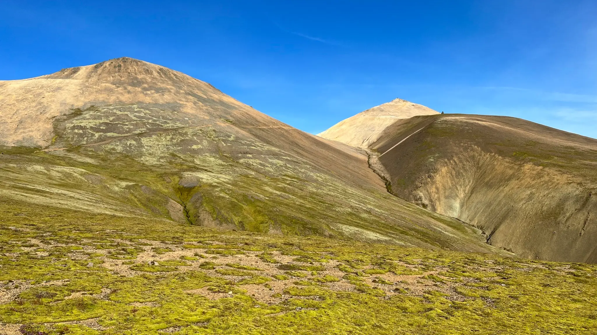 Trail ascends across the middle peak’s slope