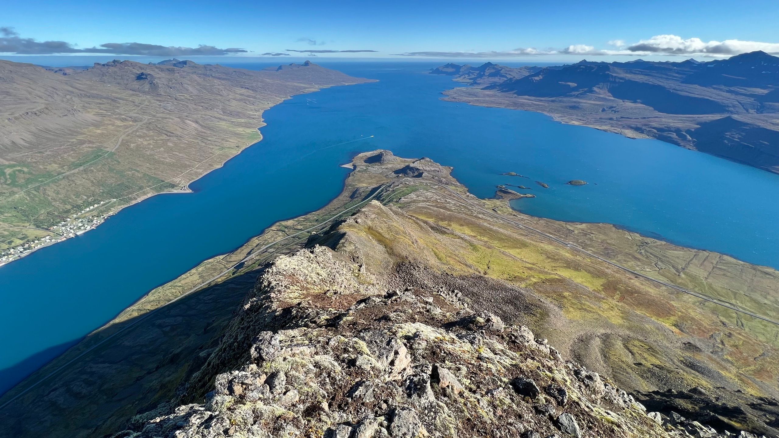 Summit ridge of Hólmatindur above the blue sweep of Eskifjörður